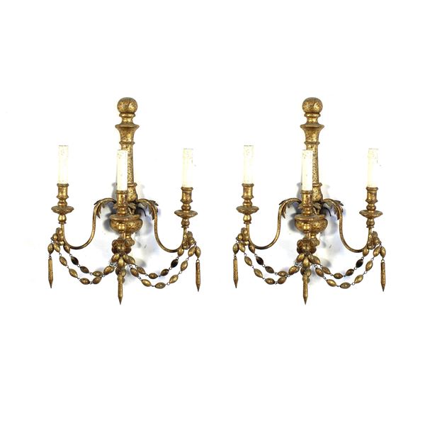 Coppia di appliques a tre luci in legno dorato