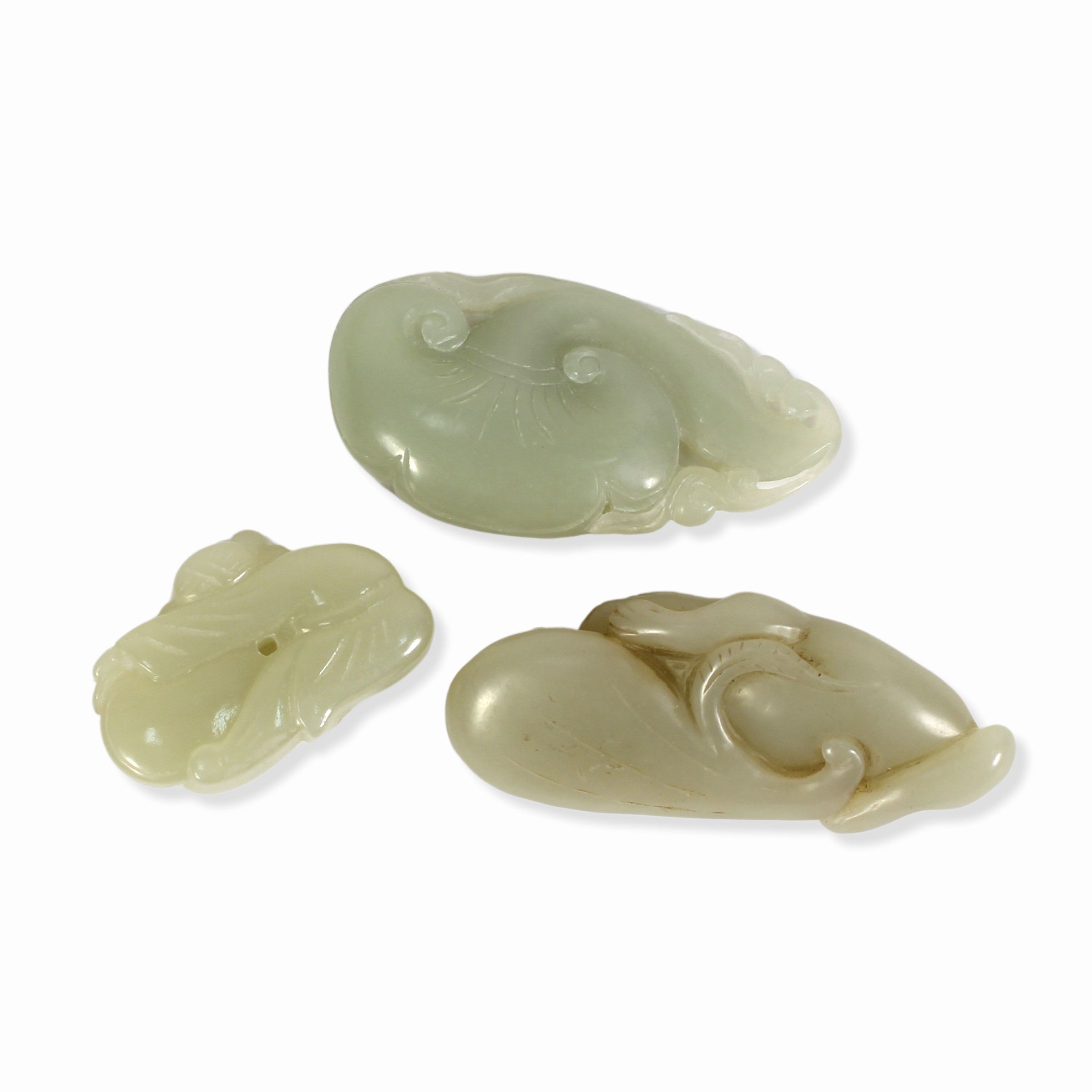 Giada cinese (Qing, XIX-XX secolo), Tre intagli in giada verde pallido raffiguranti bimbo con pes...